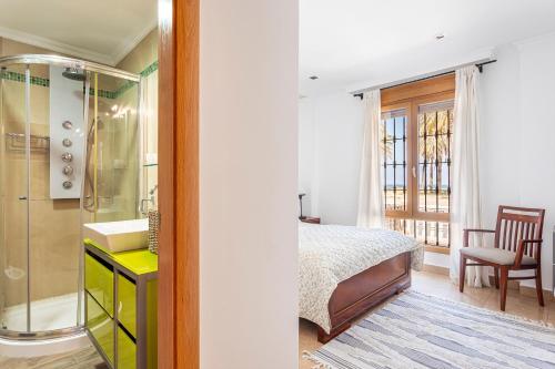 a bedroom with a bed and a bathroom with a shower at Marenostrum Villa in Valencia