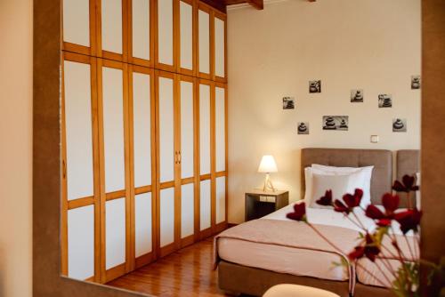 a bedroom with a bed and a window with pictures on the wall at Eleas Gi Villa in Vitalades