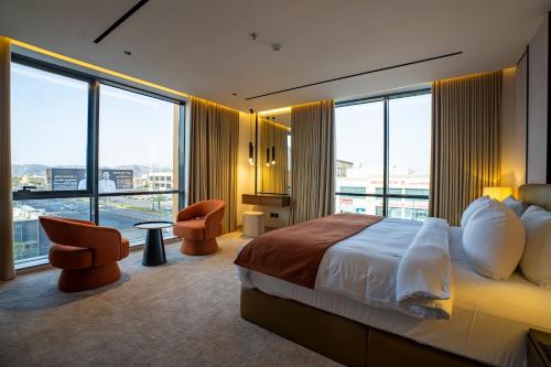 a hotel room with a large bed and large windows at فندق ليماكو in Najran