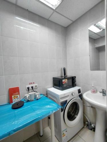 a bathroom with a washing machine and a sink at Tik-Tak Mini-Hotel in Cherkasy