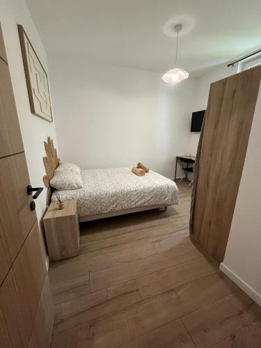 a bedroom with a bed and a door leading to a desk at Chambre privée in Vénissieux