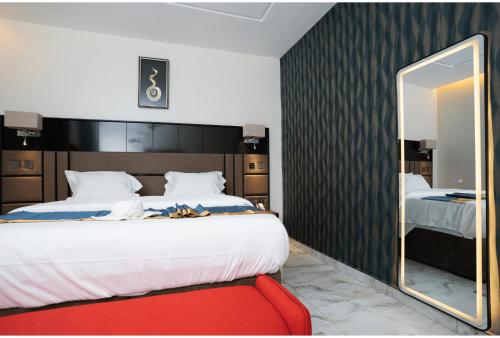 a bedroom with a large bed and a mirror at Oxvera Hotel Limited in Umuahia