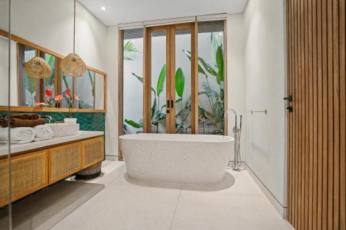 a bathroom with a bath tub and a sink at Casa de Rua Villas in Badung