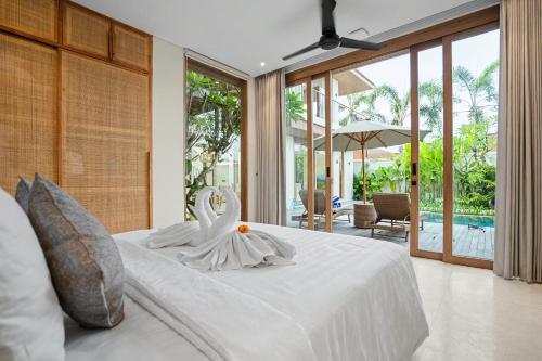 a bedroom with a white bed with a swan on it at Casa de Rua Villas in Badung