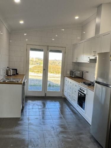 a kitchen with white appliances and white cabinets at Annabelle's Cottage in Clare