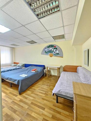 a bedroom with two beds and a table in it at Tik-Tak Mini-Hotel in Cherkasy