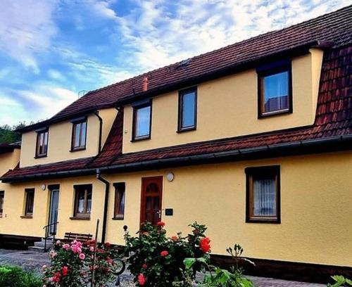 a large yellow house with a red roof at Ferienwohnung Bodenstein in Bad Liebenstein
