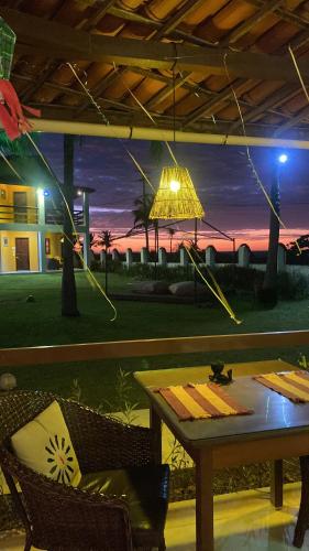 a table with a lamp and a view of the ocean at Pousada Água Azul in Flecheiras
