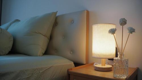a lamp on a table next to a bed at 2BR-2WC-Vinhomes Grand Park-Sunset View-VincomMeGaMall-WindyHomes in Long Bình