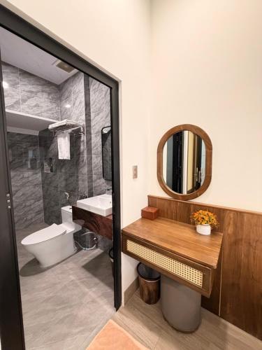 a bathroom with a sink and a mirror and a toilet at Hùng Anh Hotel in Phan Thiet