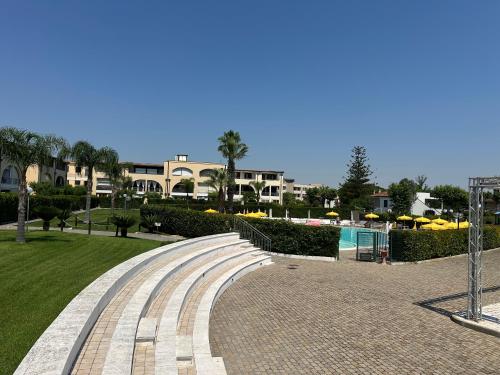 a walkway next to a swimming pool in a resort at La CASA DI LUDO in Bernalda