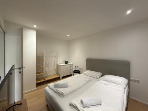 a bedroom with a large bed with white sheets at Living by Maier Altach in Altach