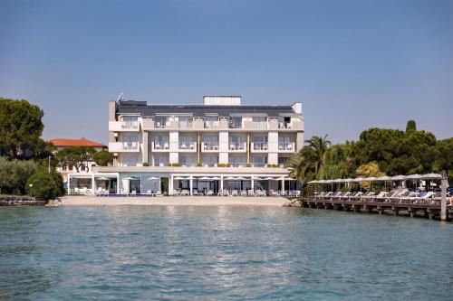 a large building on the beach with acean gmaxwell at Hotel Ocelle Thermae & Spa - Adults Only in Sirmione