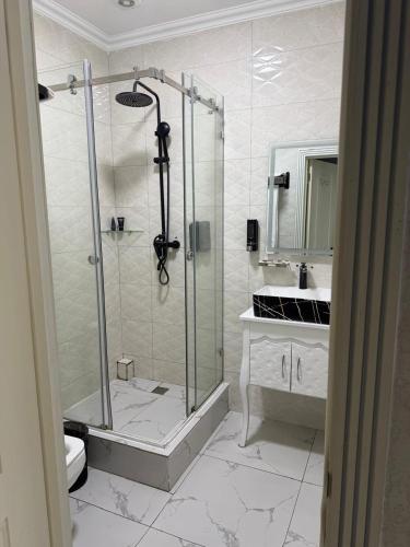 a bathroom with a shower and a toilet and a sink at Khan Plaza Hotel in Almaty