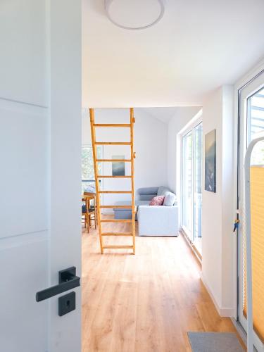 a living room with a ladder and a couch at Dywanowy Zakątek in Sominy