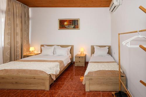 a bedroom with two beds and two lamps in it at Guest House Eno in Berat