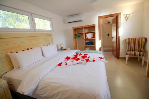 a bedroom with a large bed with red flowers on it at Shiri Beach Resort in Zanzibar City
