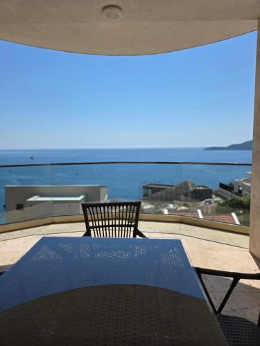 a table and chairs on a balcony with a view of the ocean at Apartments Petar in Budva