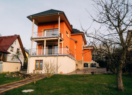 an orange and white house with a yard at Ferienwohnung Altensteinblick in Bad Liebenstein