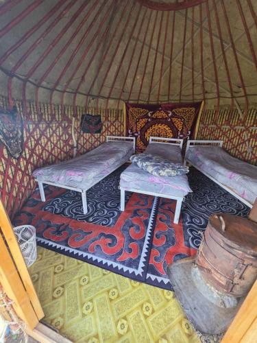 a room with two benches in a yurt at Yurtcamp Rahat&Horse Trekking in Kyzylemgek