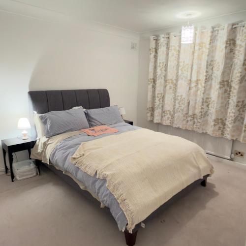 a bedroom with a large bed and a window at A beautiful stylish home in city centre in Camberley