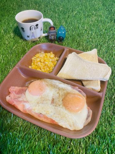 a tray with a sandwich and corn and a cup of coffee at ゲストハウスこだまのおうち in Asahikawa