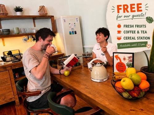two people sitting at a table in a kitchen at Baloo Hostel in Athens