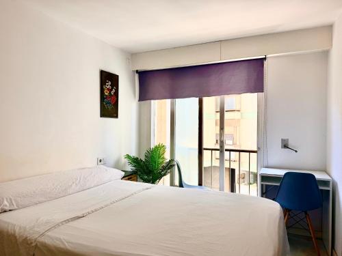 a bedroom with a bed and a large window at Guest House Leo in Alicante