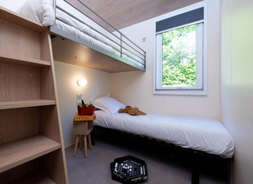 a bedroom with two bunk beds and a window at Camping La Grappe Fleurie in Fleurie