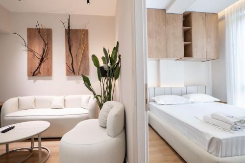 a bedroom with a bed and a couch and a table at Saturn ApartHotel Tirana in Tirana