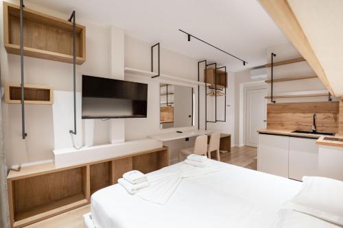 a room with a bed and a tv and a kitchen at Saturn ApartHotel Tirana in Tirana