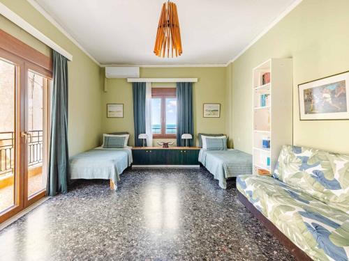 a living room with three beds and a chandelier at 4BR Newly Renovated Retreat Tranquil Coastal Haven in Hersonissos