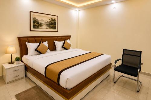 a bedroom with a bed and a chair in it at Hotel RK Palace Vrindavan - Near Bankey Bihari and Prem Mandir in Vrindāvan
