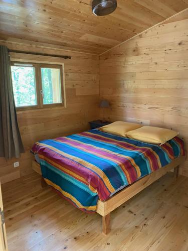 a bedroom with a bed in a log cabin at Chalets & Camping Villa Mayari in Escosse
