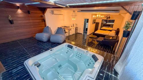 a jacuzzi tub in a room with a living room at Liberty spa & suites - שלוש סוויטות ושתי ווילות מהממות עם בריכה פרטית in Manot