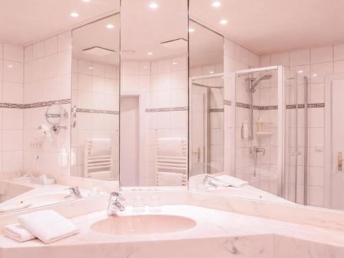a white bathroom with a sink and a shower at BE BIO Hotel be active - Nähe historischer Hafen in Tönning
