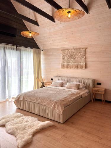 a bedroom with a large bed and wooden walls at Carpathian Barns in Abranka