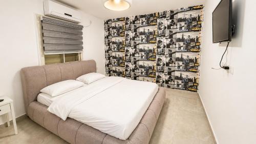 a bedroom with a bed and a tv in it at Liberty spa & suites - שלוש סוויטות ושתי ווילות מהממות עם בריכה פרטית in Manot