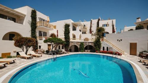 a swimming pool in front of a building at Proteas Hotel & Suites in Agios Prokopios