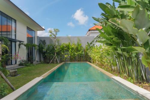 a swimming pool in front of a house at Sunset Loft Seminyak, Bali in Seminyak
