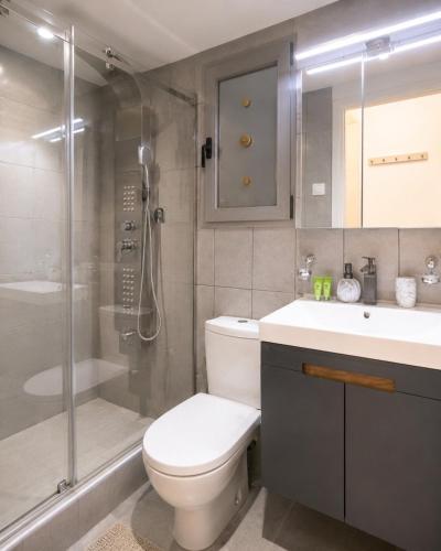 a bathroom with a toilet and a shower and a sink at Varkiza Riviera Studio by the Sea in Varkiza