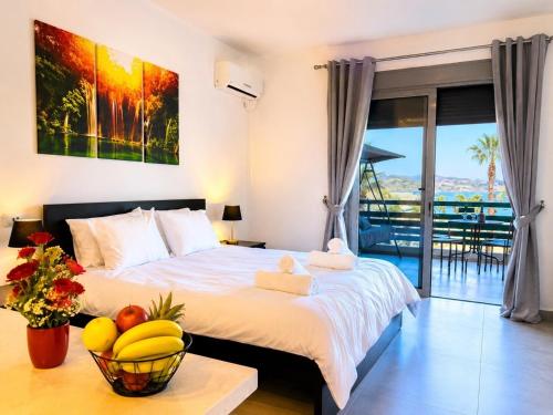 a bedroom with a bed with a bowl of fruit on a table at Varkiza Riviera Studio by the Sea in Varkiza