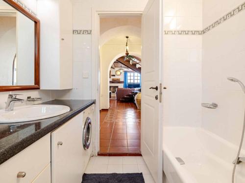 a white bathroom with a tub and a sink at Stalis Bay Villa in Stalís