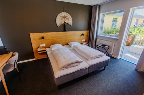 a bedroom with a large bed and a large window at Danhostel Tønder in Tønder
