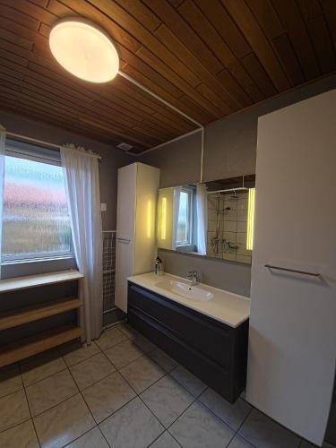 a bathroom with a sink and a mirror and a window at Glentevej 4 in Ringkøbing