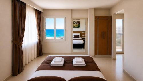 a bedroom with a large bed with a view of the ocean at Palm Beach Hotel in Silifke