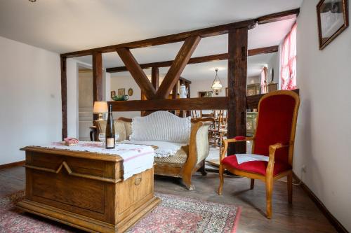 a bedroom with a bed and a red chair at voyage en Alsace chez Gaby in Hunawihr