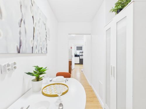 a white dining room with a white table with a plate on it at Comfort ROOM, Kochanowskiego 32 in Warsaw