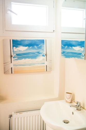a bathroom with a white sink and a window at SeaSuites Artemida in Artemida