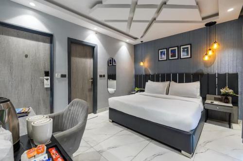 a bedroom with a large white bed and a desk at Staylo Hotel Azora in New Delhi
